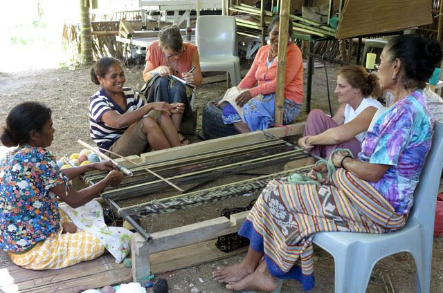 Women sharing turns at the loom